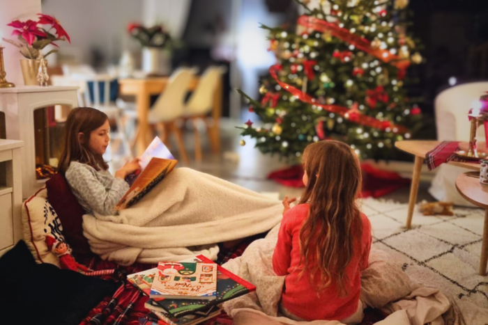 Famille réunie dans un salon décoré pour Noël, ambiance cocooning et festive