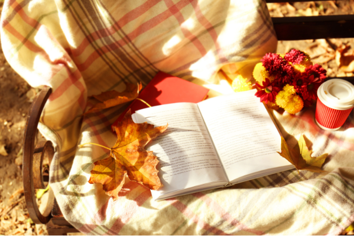 bucket list d'automne écrite dans un carnet avec une tasse de thé chaude